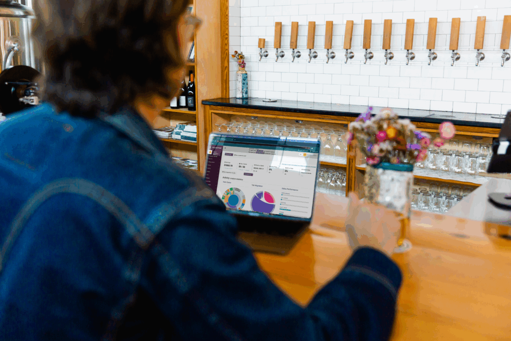 a person uses their computer while sitting at the bar in a taproom