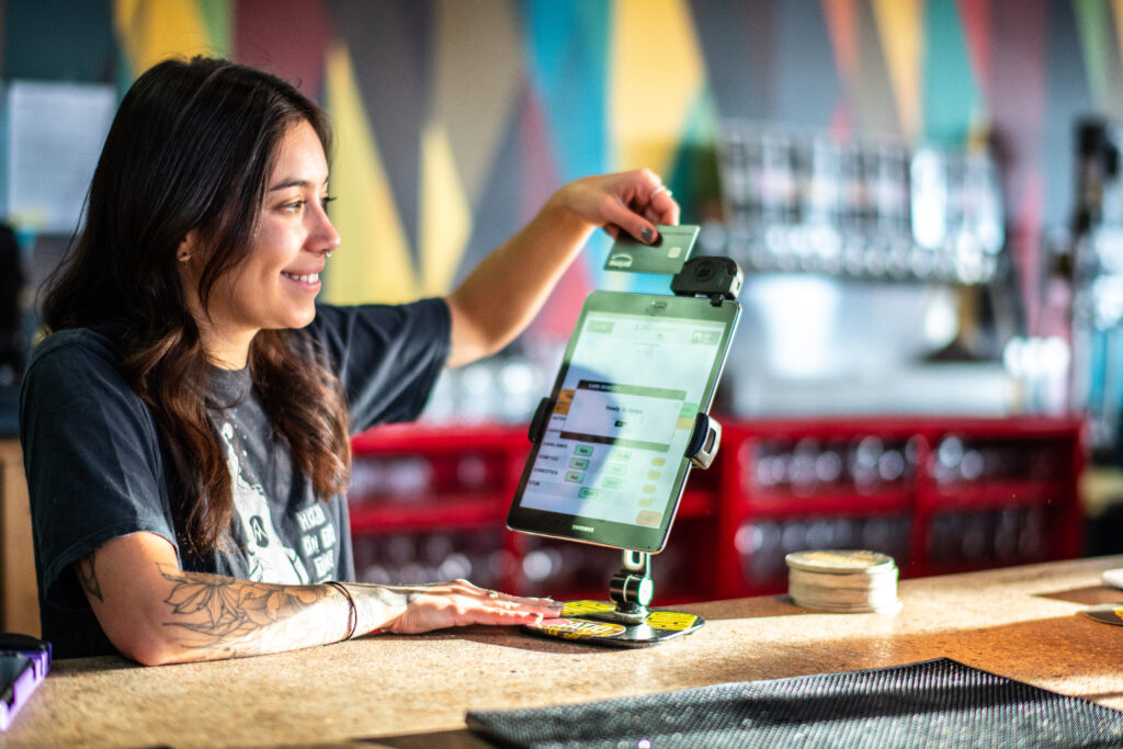 a bartender uses an Arryved POS tablet